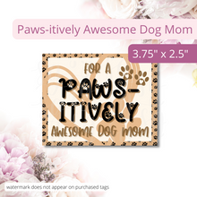 Load image into Gallery viewer, Image of cute tan colored tag with black paw prints in the background. It says: For a Paws-itively Awesome Dog Mom. Has a cute heart with a paw print under the text. Text overlay on image reads: Paws-itively Awesome Dog Mom. 3.75 x 2.75.